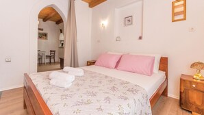 A bedroom with a wooden bed, a nightstand, a lamp, and a mirror. - 1 bedroom beautiful home in Zdrelac (Zdrelac)