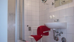 Een badkamer met een douche, wastafel en toilet.