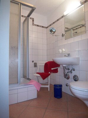 Une salle de bain avec une douche, un lavabo et des toilettes.