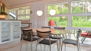 A modern kitchen with a dining area, large windows, and a view of greenery. - 3 bedroom stunning home in Sæby (Sæby)