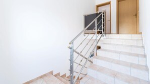 Un escalier avec des rampes en métal et des carreaux de couleur beige.