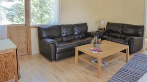 A living room with two black leather sofas, a wooden coffee table, and a small wooden side table. - Beautiful home in Trosa (Trosa)