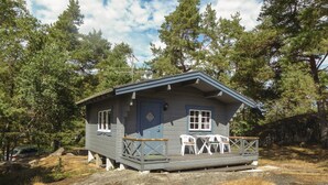 A small cabin with a porch, white chairs, and a table. - Beautiful home in Trosa (Trosa)