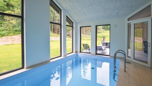 A swimming pool with clear views of a garden and outdoor seating area. - Lovely home in Ebeltoft with sauna (Ebeltoft)