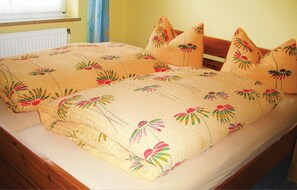 Een tweepersoonsbed met bloemenbedrukte lakens en bijpassende kussens.