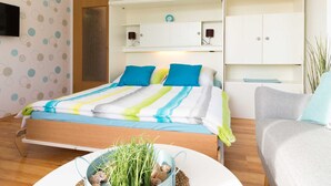 A bedroom with a bed, a bedside table, a chair, and a wardrobe. - Apartment Scholle - CuxDuHier (Cuxhaven)