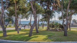A landscaped area with trees and a view of the sea. - Beach front apartment in Mijas Costa (Mijas Costa)
