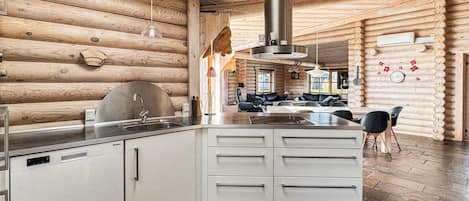 L’intérieur d’une cabane en rondins comprend une cuisine, un coin repas et un espace de vie.