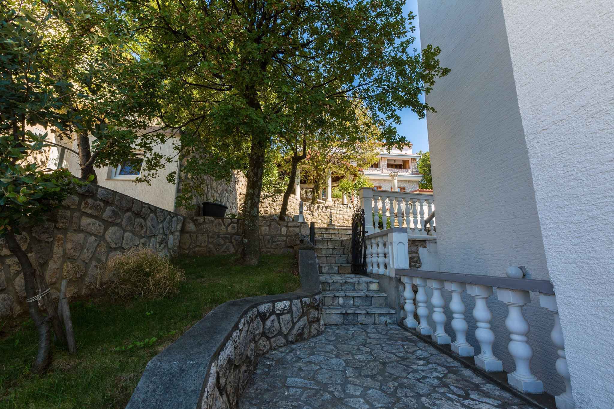 Una escalera de piedra que conduce a un edificio blanco con un balcón.