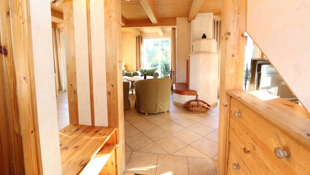 Un interno in legno con zona pranzo, divano e camino.