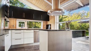 Een moderne keuken met zwarte kasten, witte lades en een groot eiland.