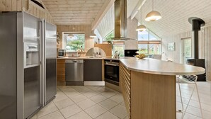 A modern kitchen with wooden cabinets, stainless steel appliances, and a large island. - Beautiful home in Ebeltoft with WiFi (Ebeltoft)