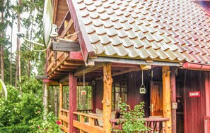 Une cabane en bois avec un toit en tuiles, une véranda avec des sièges et un panneau indiquant qu’il s’agit d’un espace privé.