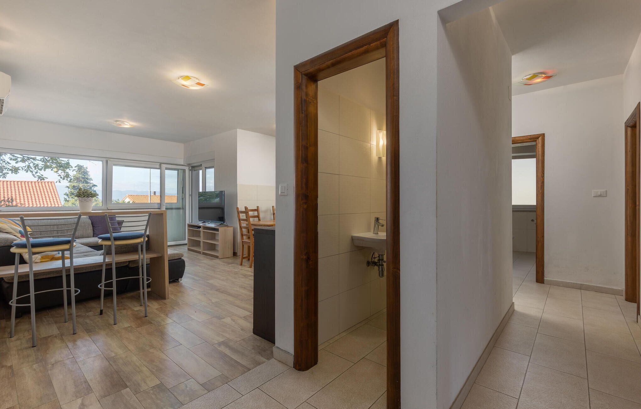 A modern interior with a dining area, a TV, and a bathroom.