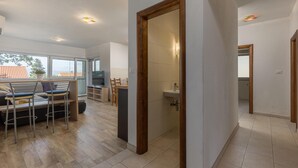 Un intérieur moderne comprenant un coin repas, un téléviseur et une salle de bain.