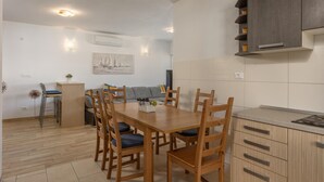 Une cuisine moderne avec des meubles en bois, une table à manger avec des chaises et un îlot de cuisine.