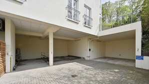 A building with a covered entrance, a staircase, and a paved courtyard.