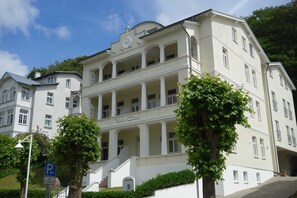 A large, white building with a central staircase and multiple balconies.