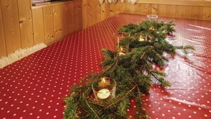 A cozy room with a red polka dot tablecloth, a Christmas tree with candles, and wooden walls. - Gorgeous home in Sjusjøen with sauna (Sjusjøen)