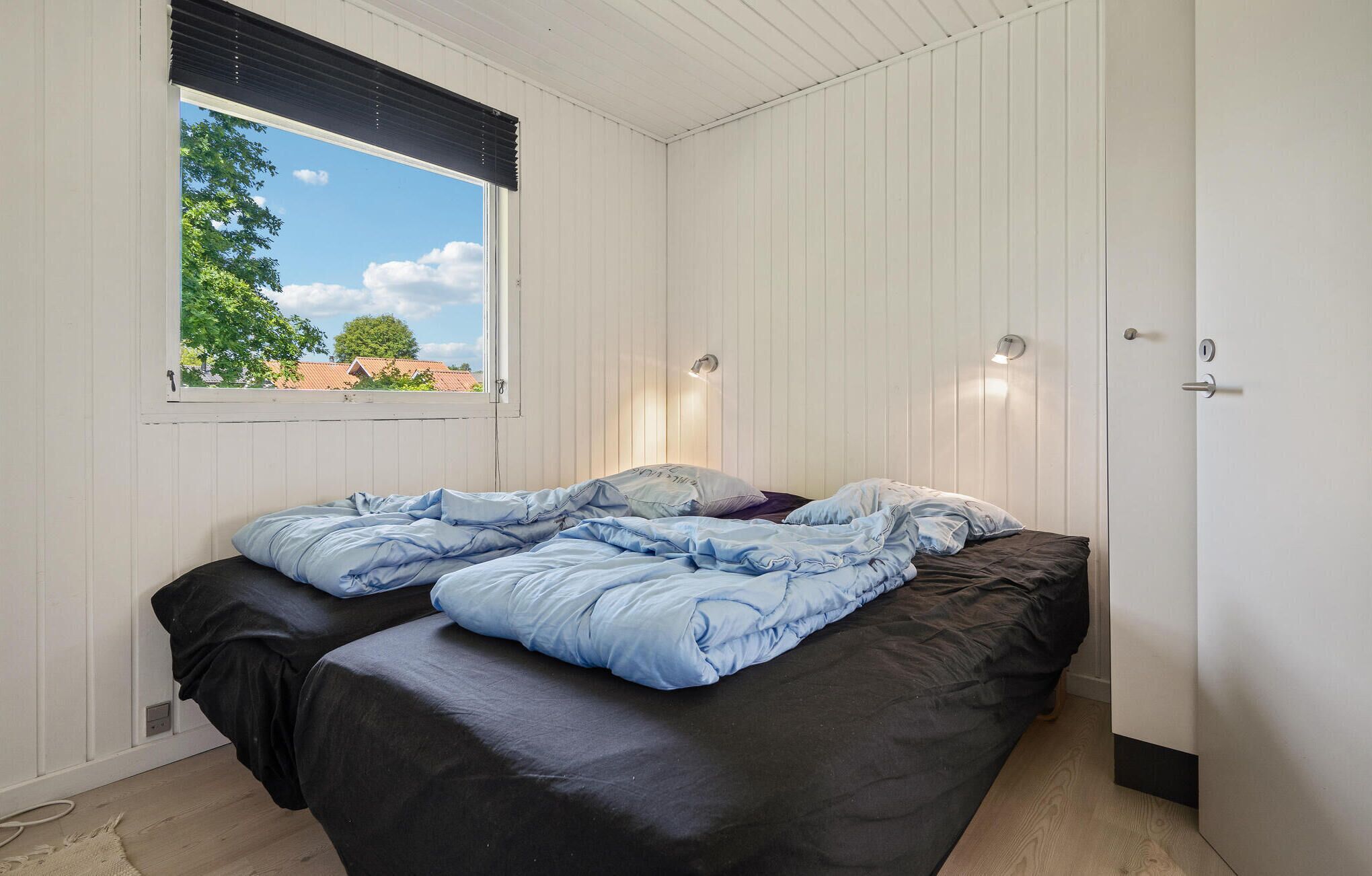 Une chambre à coucher avec un lit, une fenêtre et une porte.