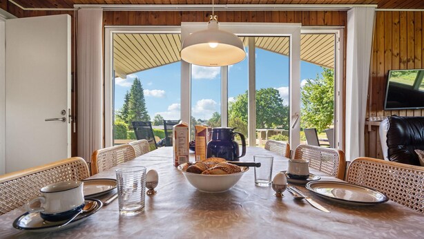 A dining area with a table set for four, a bowl of bread, and a coffee pot. - 3 bedroom gorgeous home in Hejls (Hejls)