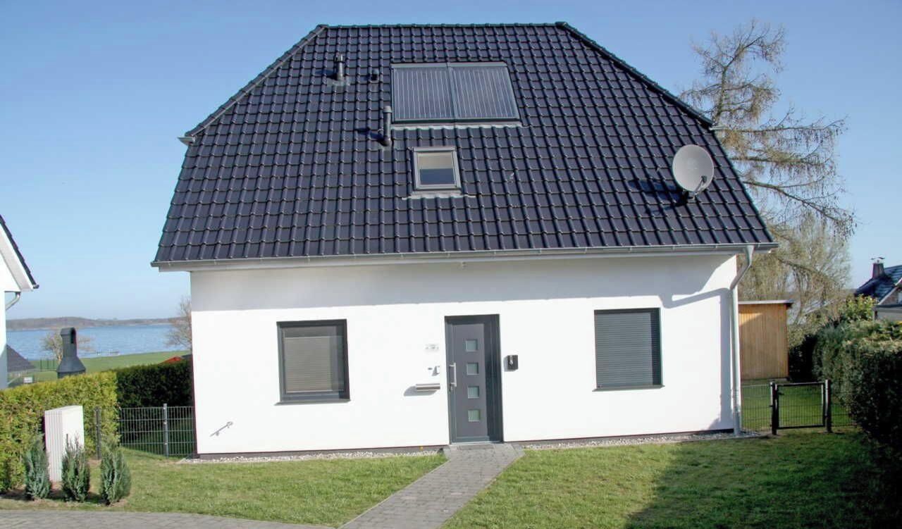A single-story house with a dark tiled roof, a small window, and a door.