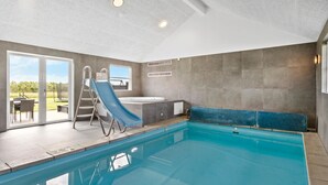 An indoor swimming pool with a slide, a hot tub, and a view of the outdoors. - Cozy home in Løkken with WiFi (Løkken)
