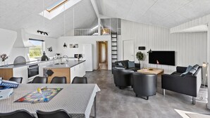 A modern interior with a kitchen, dining area, and living room. - Cozy home in Løkken with WiFi (Løkken)
