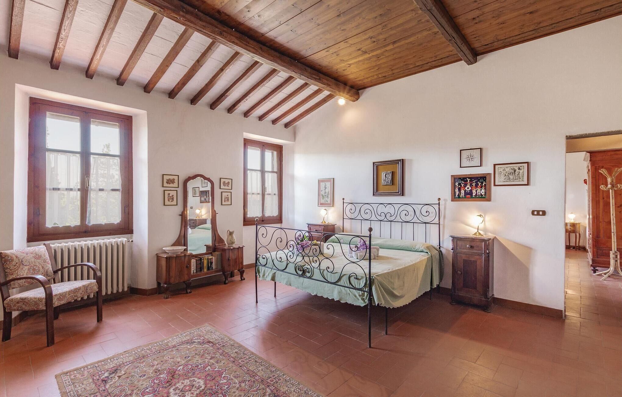 A cozy bedroom with a bed, a wooden chair, a radiator, and a window.