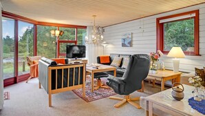 A modern living room with a sofa, a black leather chair, a TV, and a dining table. - Pet friendly home in Rømø (Rømø)