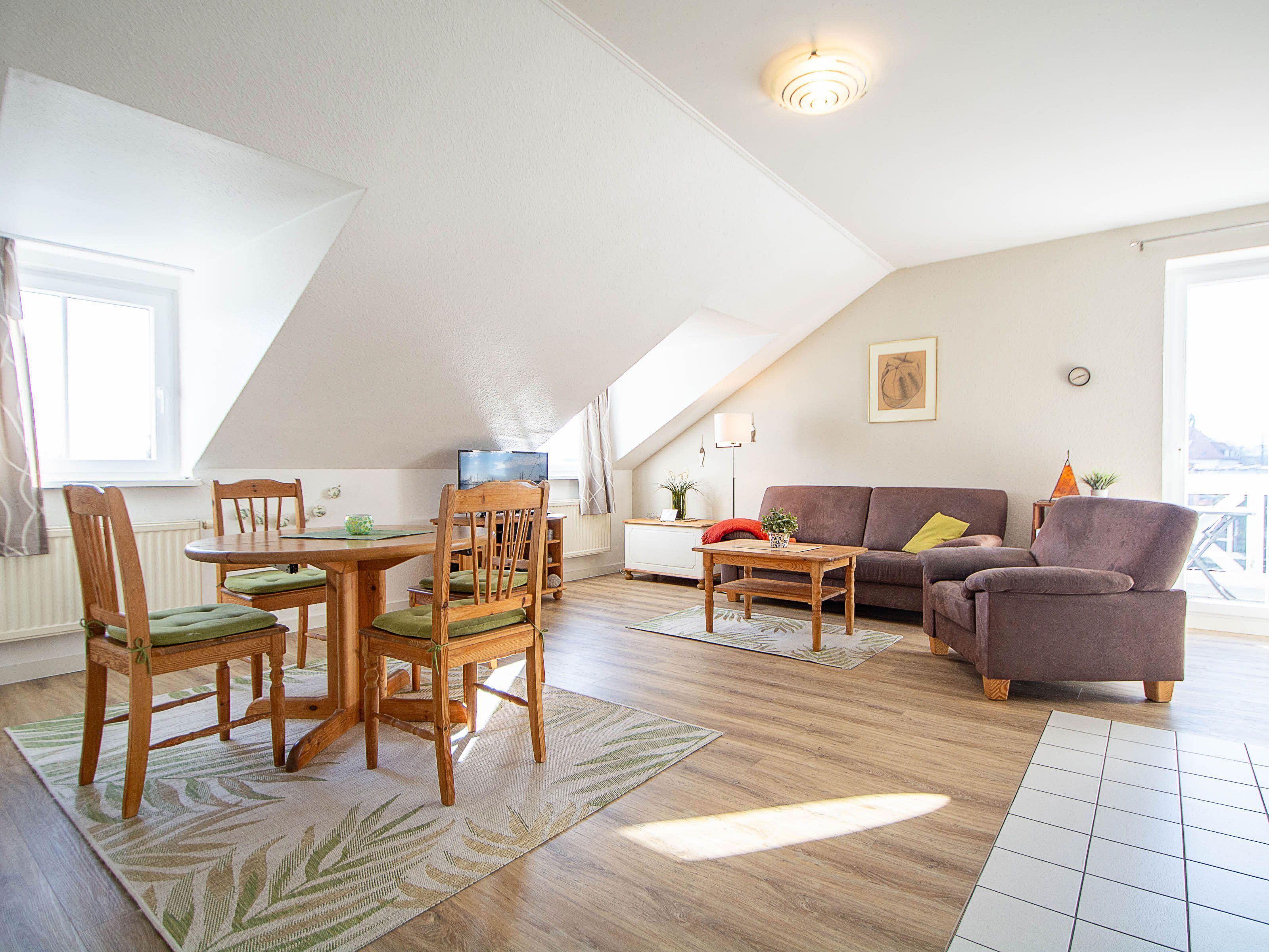 Un espacio habitable estilo loft con comedor, sofá y televisor.
