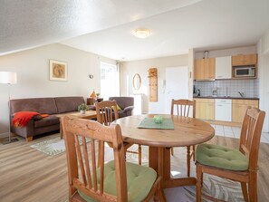 Un espace de vie compact comprenant un coin repas, une kitchenette et un canapé.