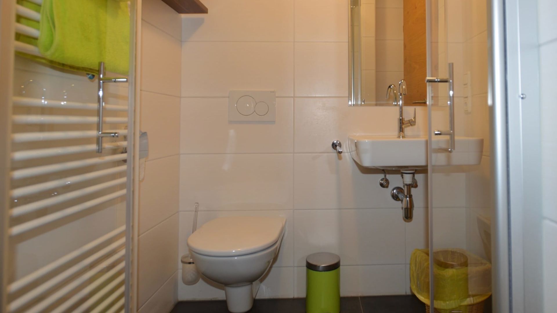 Une petite salle de bain avec des toilettes, un lavabo et une poubelle.