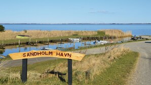 A wooden sign with the text "Sandholm Havn" indicating a location.