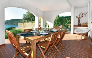 Enjoy meals al fresco under a charming archway with a view of the surrounding water and lush greenery.