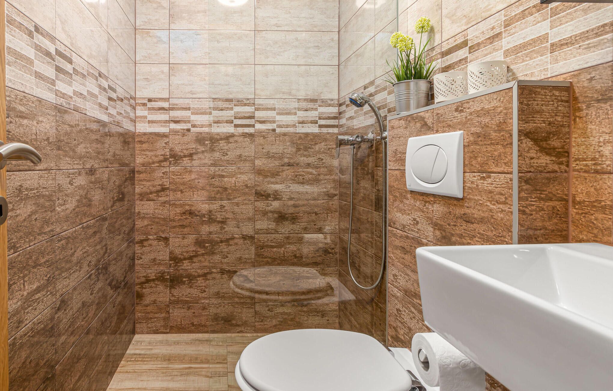 A bathroom with a shower, toilet, and a bathtub.