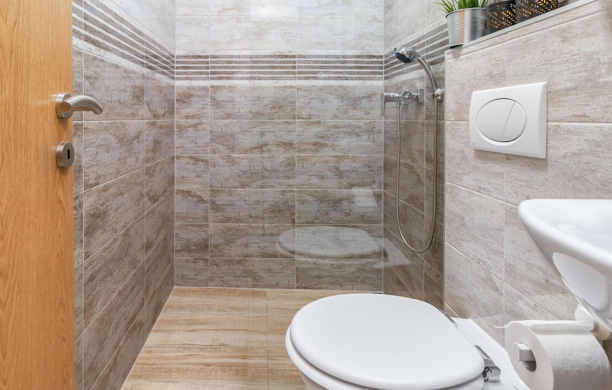 A bathroom with a shower, toilet, and sink.