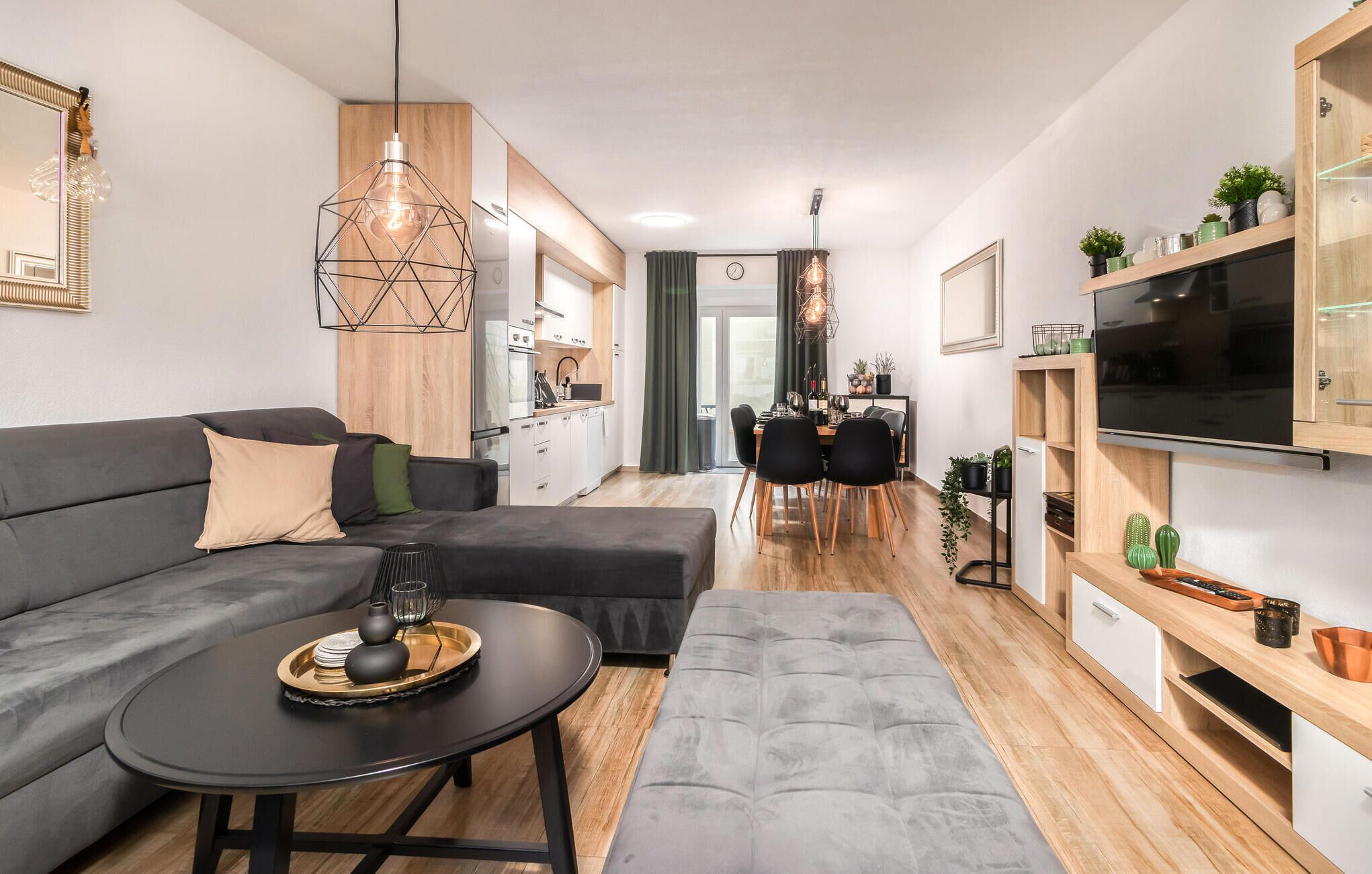 Un salon moderne avec un canapé, une table basse et un téléviseur.