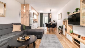 Una sala de estar moderna con un sofá, una mesa de centro y un televisor.