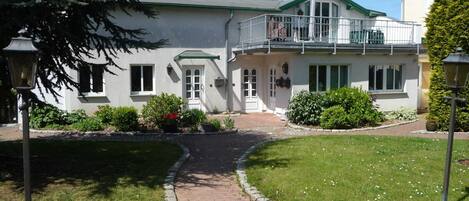 A two-story house with a brick pathway leading to the entrance.