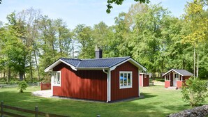A red cabin with a gabled roof, a chimney, and a small porch. - 1 bedroom awesome home in Sölvesborg (Sölvesborg)