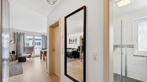 A modern interior with a hallway leading to a living area and a bathroom. - Ferienhaus 31 Altefähr (Altefähr/Rügen)