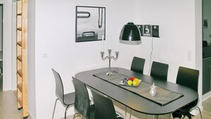 Un comedor con una mesa oscura, sillas negras, un candelabro y un frutero.
