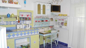 A kitchen with a microwave, toaster, and various kitchen utensils on the counter. - Holiday apartment near the beach with air conditioning (Baška)