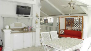 A room with a television, a white sink, a dining table, and a red bench. - Holiday apartment near the beach with air conditioning (Baška)
