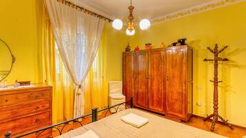 Ein Zimmer mit Bett, Holzschrank und Spiegel.