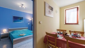 Una stanza con un letto, un tavolo da pranzo per due persone e un quadro appeso al muro.