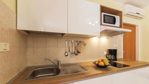 Una cucina moderna con lavello in acciaio inossidabile, un forno a microonde e una macchina per il caffè.