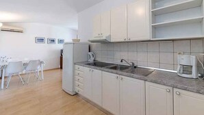 Una cocina moderna con armarios blancos, un lavamanos doble y una cafetera.