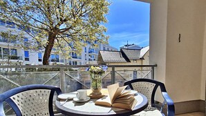 A balcony with two chairs, a table, a vase with flowers, and a book. - Vacation apartment 1.1.10 Inselstrand - Holiday apartment 1.1.10 Lottchen (Heringsdorf)